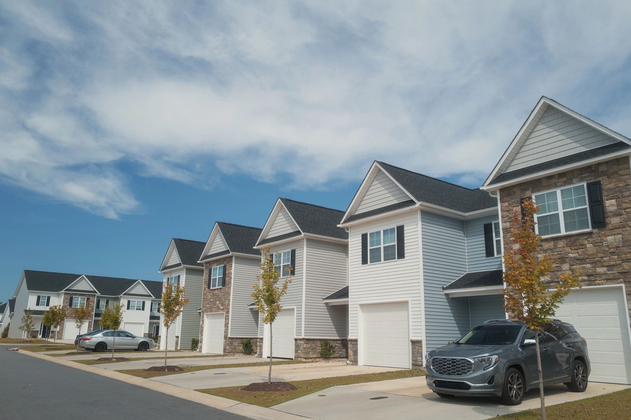 Row of modern townhomes under a clear blue sky